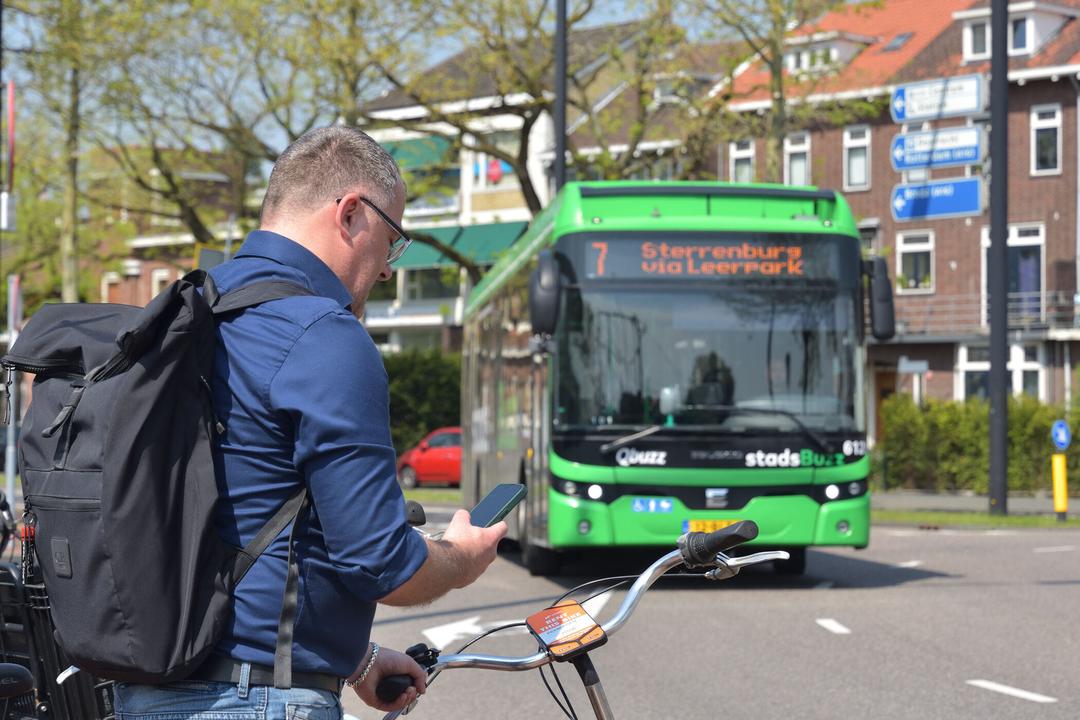 Drie reizigers staan in de rij voor de bus